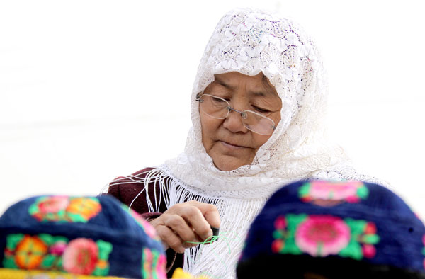 A woman makes stitches embroidery in Huayuan village, March 11, 2013. New skills for better jobs in Xinjiang