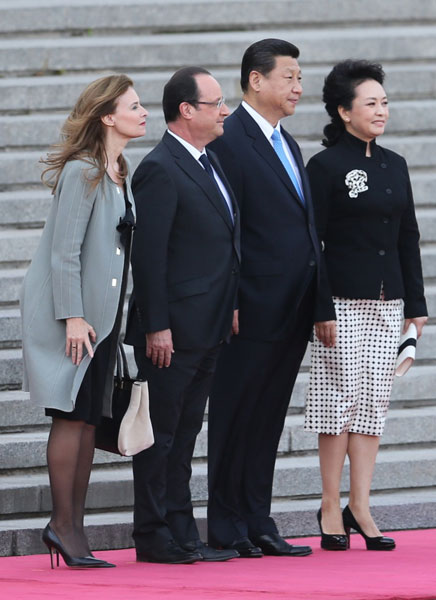 President Xi Jinping and his wife Peng Liyuan welcome French President Francois Hollande and partner Valerie Trierweiler in Beijing on Thursday. Xu Jingxing / China Daily Meeting delivers big deals