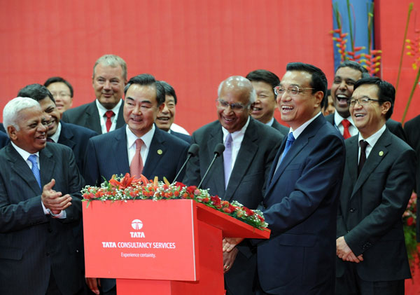 Premier Li Keqiang laughs during a video conference with Chinese employees of India's tea-to-software conglomerate Tata Group at the Tata Consultancy Services software facility in Mumbai on Tuesday. INDRANIL MUKHERJEE / AFP China, India in talks on trade strategy: Li