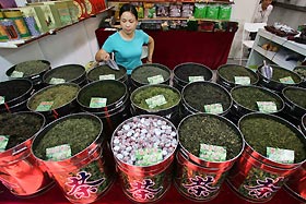 A shop vendor waits for customers at her tea counter in Shanghai October 12, 2006. 