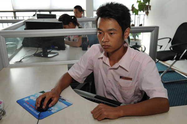 Jing Weiquan gets to grips with his new computer workspace in the office of an IT company in Southwest China's Chongqing municipality, July 19, 2011 Gutsy 7 day, 360 km hike to find a job