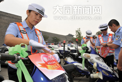 綜警隊員往車上粘送考車貼、捆綠絲帶