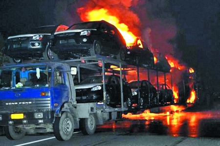 輪胎爆裂火燒連營(yíng) 車上15輛新車變成光架架
