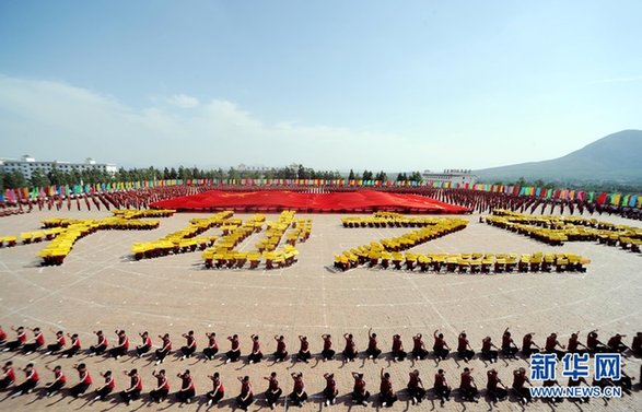 少林寺塔溝武校舉行萬人武術(shù)表演 拼出巨幅國(guó)旗圖案