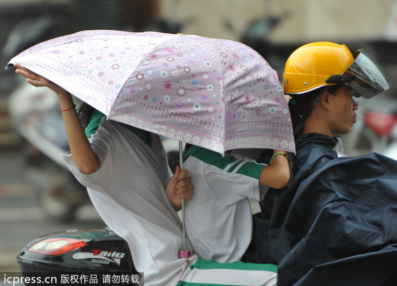 臺風(fēng)“百合”逼近海南 瓊海市民躲雨避風(fēng)各有高招