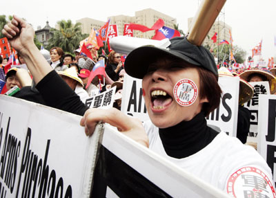A protestor holds a sign opposing arms purchases from the U.S. sought by Taiwan President Chen Shui-bian in a rally organized by the main opposition parties in Taipei, March 19, 2006. Thousands of supporters gathered a few hundred meters from the Presidential building in the protest, which marked two years since the mysterious election-eve shooting of Chen, which the opposition has said was staged to win votes in the election. Protestors also called for a new investigation into the incident. 
