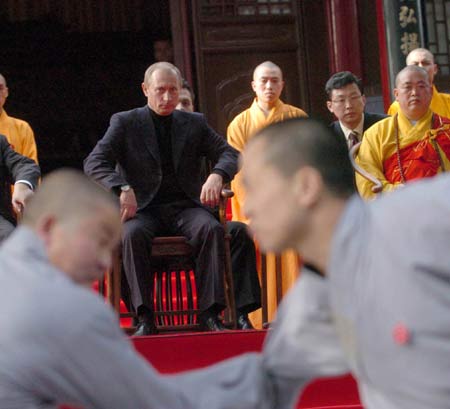 Russian President Vladimir Putin watches monks perform martial arts during a visit to the Shaolin Temple in Central China's Henan Province March 22, 2006. Shaolin Temple is widely believed as the origin of martial arts. [Xinhua]