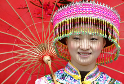 A Chinese woman dressed in traditional ethnic minority costume performs during a celebration at the 23rd Weifang International Kite Festival in Weifang, China's Shandong province, April 21, 2006. 