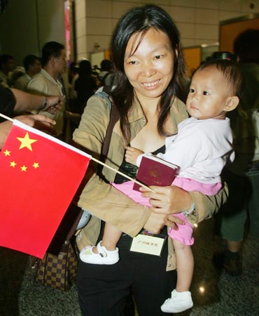 Solomon Islanders of Chinese descent, carrying a Chinese national flag, arrive at an airport in Guangzhou, southern China's Guangdong province early April 25, 2006. More than 300 Chinese, including some from Hong Kong, board a chartered flight provided by Beijing that evacuated them from the troubled Solomon Islands after they lost all their possessions in the recent riots in Honiara. 