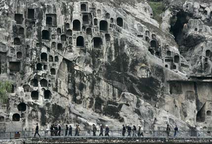 Tourists visit Longmen Grottoes in the city of Luoyang in China's central province of Henan May 12, 2006. "Longmen Grottoes" is one of China's UNESCO World Heritage sites in Henan Province. Longmen has more than 2,300 grottoes with 110,000 Buddhist images, over 80 dagobas and 2,800 inscribed tablets on cliffs with a length of one kilometre along the Yishui River, where Buddhism was first introduced to China during the Eastern Han Dynasty (25 - 220), according to Xinhua News. [Reuters]