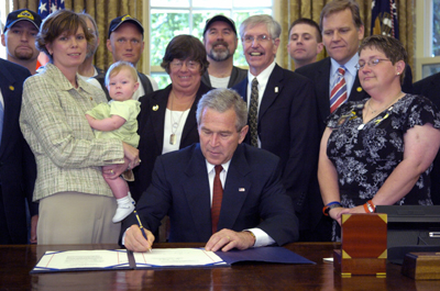 U.S. President George W. Bush signs one of a pair of military-related bills into law in the Oval Office in Washington, May 29, 2006. The Respect for America's Fallen Heroes Act limits some protests at military funerals, and the Heroes Earned Retirement Opportunities Act changes the way members of the military can contribute to individual retirement accounts from combat pay. [Reuters]