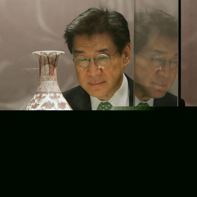 Theow Tow, Deputy Chairman of Christie's Asia and the Americas International Director of Chinese works of Arts, looks at an early Ming underglaze copper-red vase after it was sold for a world record of US$10,122,558 for any Ming porcelain during an auction in Hong Kong May 30, 2006. 