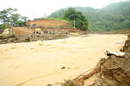 Floodwater destroys road and bridge in Wangmo, southwest China's Guizhou province, June 17, 2006. Heavy rainstorms hit Wangmo again, where flash floods have killed at least 52 people, with another 20 still missing earlier this month, Xinhua reported. [Newsphoto]
