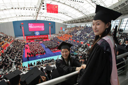 A student takes a picture of his friends in front of the Chinese flag during a graduation ceremony at Fudan University in Shanghai June 28, 2006.[