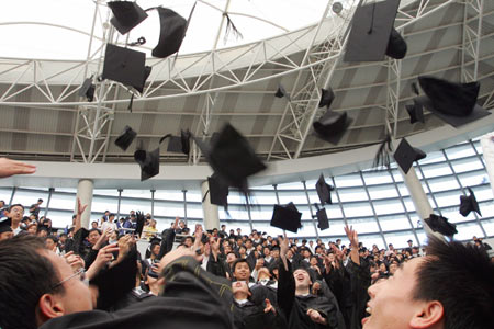 A student takes a picture of his friends in front of the Chinese flag during a graduation ceremony at Fudan University in Shanghai June 28, 2006.[