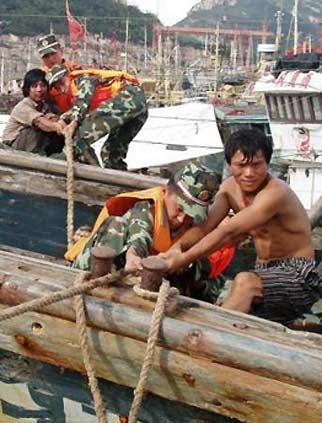 Paramilitary policemen help residents tie up boats against the upcoming typhoons in Taizhou, east China's Zhejiang province August 8, 2006. As millions of people in south China still struggle with the aftermath of typhoon Prapiroon, two new tropical storms Bopha and Saomai are approaching and expected to affect coastal areas in southeastern China, China Daily reported. Picture taken August 8, 2006. 