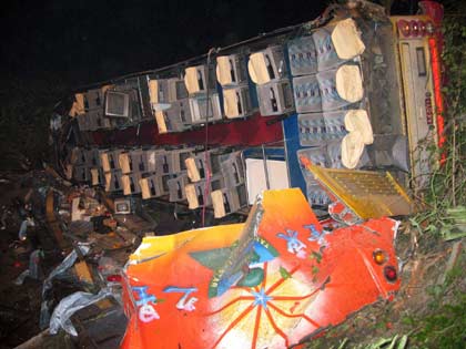 A tour bus lies on its side after falling from a mountain road in Taiwan's central Nantou county late October 2, 2006. The bus, carrying tourists from China, fell from a mountain road into a deep valley in central Taiwan on Monday, killing six and injuring 14 others. Picture taken on October 2, 2006. 