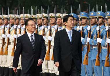 Chinese Premier Wen Jiabao (R) and Japanese Prime Minister Shinzo Abe review a guard of honor during a welcoming ceremony at the Great Hall of the People in Beijing, October 8, 2006. Abe arrived in Beijing for a two-day visit to mend ties with China.[AP Photo]