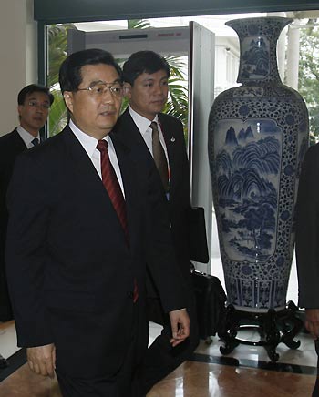 China's President Hu Jintao (C) is escorted by security personnel as he leaves a hotel in Hanoi November 18, 2006. Hu is in Vietnam to attend the Asia-Pacific Economic Cooperation (APEC) summit. 