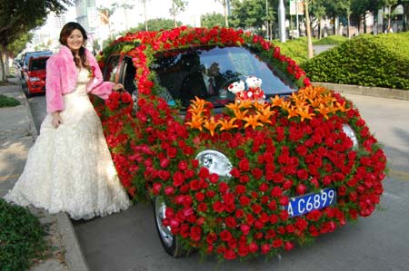 A bride poses for a picture with a car decorated with flowers in Nanjing, South China's Guangxi Zhuang Autonomous Region January 7, 2007. [newsphoto]