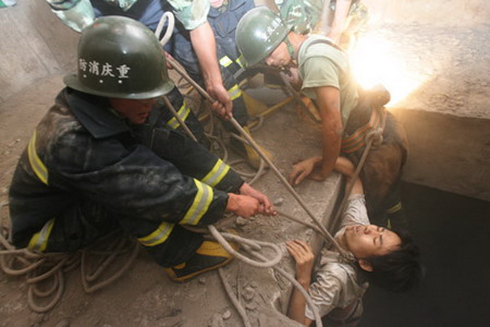 Firemen rescue Liu Jie, who was trapped in a bridge abutment for 26 hours, in Chongqing��July 16, 2006. Liu Jie fell into the abutment by accident and attracted people's attention by setting on his clothes on fire with a lighter. [Wang Yuanling/Chongqing Times]