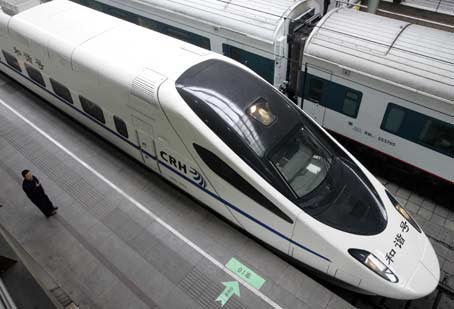 A staff member stands at attention as a high-speed train leaves Beijing railway station April 18, 2007. High-speed trains with a speed of 200km (124 miles) per hour or more will hit Chinese railways on Wednesday, marking the start of the system's sixth 