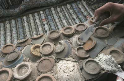 A worker decorates a house with ceramic chips in Tianjin April 22, 2007. The house, which will soon be converted into a restaurant, cost some 500 million yuan ($65 million) to build and contains more than 400 million pieces of porcelain, the restaurant's manager Hou Xiaoyu claimed. Picture taken April 22, 2007. 