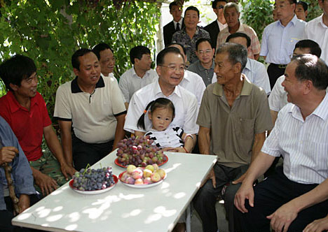 Chinese Premier Wen Jiabao (C) talks with local people at a villager's home during his inspection tour to the northwestern Xinjiang Uygur Autonomous Region from last Thursday to Sunday. Wen Jiabao visited villages, schools, enterprises, hospitals and the Xinjiang production and construction corps of the army in a number of prefectures and cities to show his extensive care for local people's livelihood, education, medical service and the development of energy sources，Xinhua reported.[Xinhua]