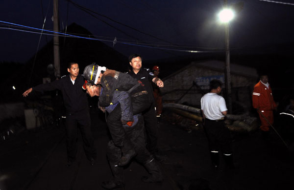 A miner rescued from a flooded pit of the Hengtai Coal Mining Co is carried away in Boli county, Northeast China’s Heilongjiiang province, August 27, 2011. 3 of 26 trapped rescued after NE China mine flood