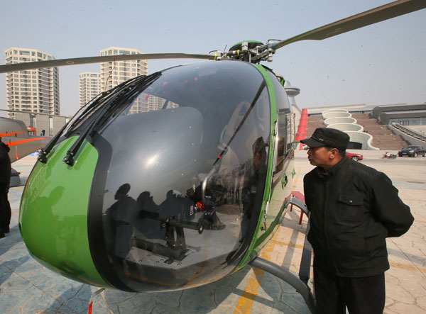 A visitor checks a helicopter on sale at a private aircraft store in Beijing on Saturday. JIANG GUIJIA / FOR CHINA DAILY Private aircraft stores opening across China