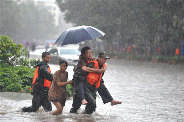 soldier carries a man through the urban flooding brought by rainfall in Kunming Rain triggers flooding in SW China city