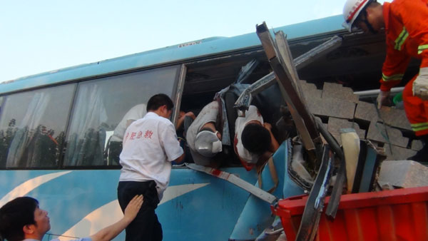Rescuers try to pull the victims out of the coach crashed in a road accident in Hefei city, East China's Anhui province, Aug 9, 2013. 10 killed in E China expressway collision
