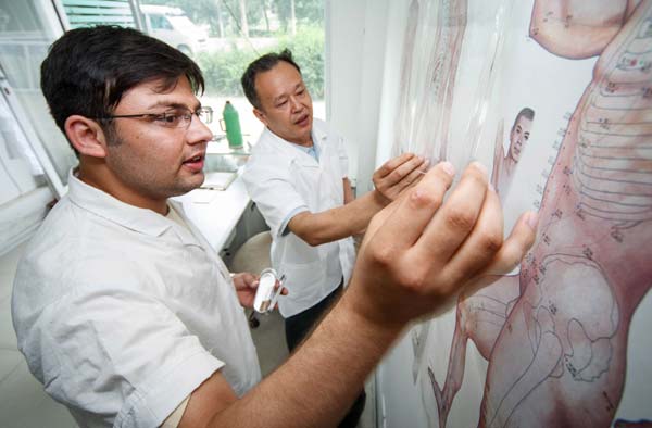 A Pakistani student, whose Chinese name is Mu Yang, studies traditional Chinese medicine at a clinic in Nantong, Jiangsu province. The 25-year-old graduated from Nantong University earlier in the summer. Huang Zhe / Xinhua Universities seek greater enrollment from abroad
