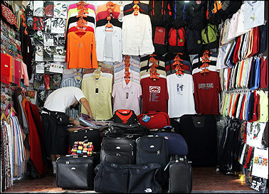 A vendor counts merchandise at his storefront in Beijing 05 September 2005.