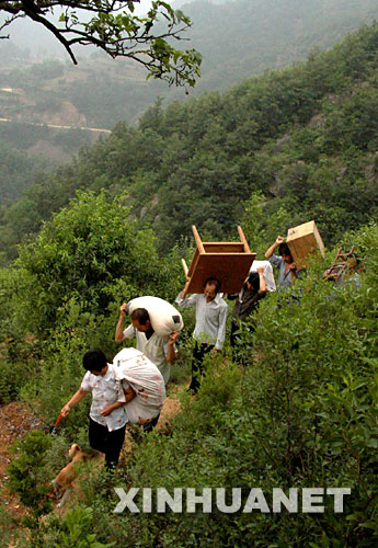 這是嵩縣木植街鄉(xiāng)的一批深山獨(dú)居戶搬運(yùn)物品下山，準(zhǔn)備遷入新居（2002年6月26日攝）。 河南省嵩縣是國(guó)家扶貧工作重點(diǎn)縣。為徹底改變部分生活在深山區(qū)、被“行路難、用電難、吃水難、上學(xué)難、就醫(yī)難”困擾的村民的生活狀況，從2002年開始，嵩縣把“異地安置、搬遷扶貧”作為山區(qū)扶貧開發(fā)的切入點(diǎn)和深山群眾脫貧致富的途徑，有計(jì)劃、分期分批地把他們搬遷到小城鎮(zhèn)和交通便利的村莊。5年來，嵩縣通過多種形式，新建移民新村53個(gè)，遷出深山貧困群眾3238戶、13151人。 新華社記者 王頌攝 