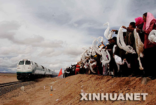 2006年7月1日，青藏鐵路全線通車，標(biāo)志著西藏結(jié)束了不通火車的歷史。青藏鐵路自西寧至拉薩全長(zhǎng)1956公里，包括西寧至格爾木和格爾木至拉薩兩段。這是在位于青海境內(nèi)的沱沱河大橋橋頭，當(dāng)?shù)厝罕姎g迎從格爾木出發(fā)的“青1”次列車（2006年7月1日攝）。 新華社發(fā) 