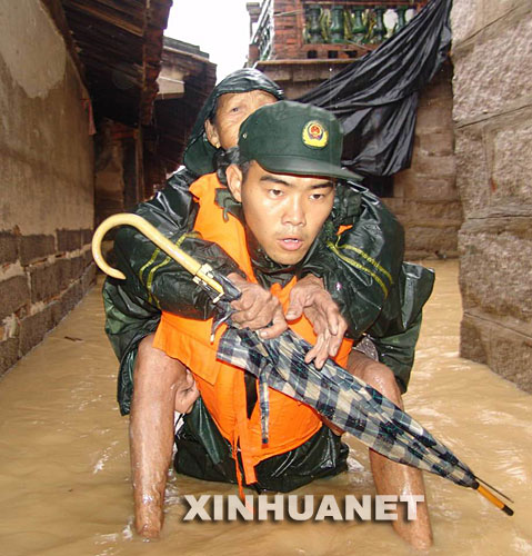  2006年7月16日，在福建省龍海市程溪鎮(zhèn)官園村，福建省武警總隊漳州支隊官兵奮勇轉(zhuǎn)移被洪水圍困的群眾。 新華社發(fā) 