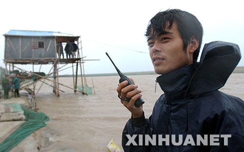 2005年7月19日，臺風(fēng)“海棠”襲來，浙江省慈溪市安東鎮(zhèn)消防員苗建波與鎮(zhèn)里的黨員干部一起，組織住在海邊的漁民撤離到安全區(qū)域。 新華社發(fā) 