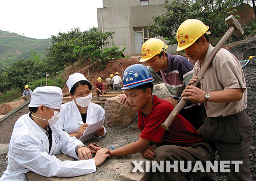  2003年5月9日，中鐵二局巡回防疫小分隊的醫(yī)務人員在成都市龍泉驛區(qū)白工堰建設工地為施工人員檢查身體。為預防非典傳播，中鐵二局醫(yī)務人員深入各建設工地，為施工人員和駐地山村群眾免費檢查身體，宣傳防疫知識。 新華社發(fā) 