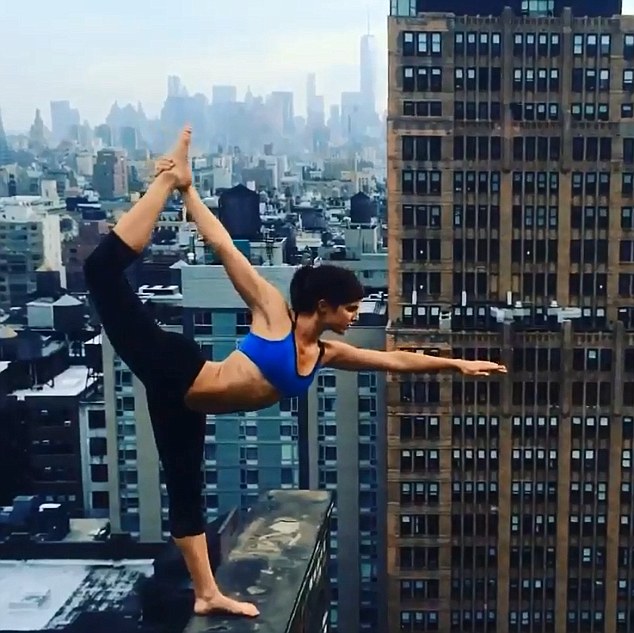 Yogi poses on building ledge<BR>美女子頂樓邊緣練瑜伽