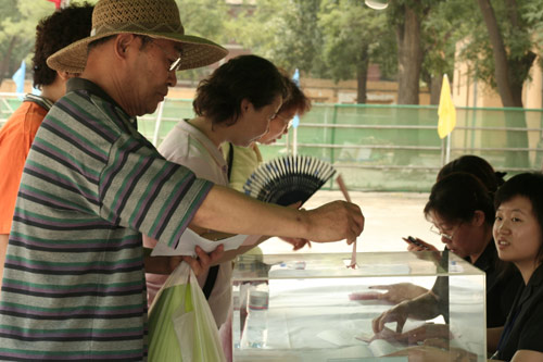 A voter casts his vote on demolishment and reconstruction of old buildings in Juixiaqiao Sub-district in Beijing, June 9, 2007. Local government and the real estate developer jointly organize the vote on Saturday to see if majority residents of over 5000 families accept the new compensation policy after failed attempts to reach an agreement through other ways. Both notary officials and supervisors are invited to monitor the vote that runs from 9 a.m. to 9 p.m. at six ballot booths. [Sun Yuqing/www.midnightarchive.com]