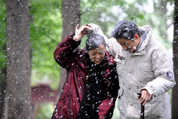 Zhang Jing and his wife Yao Zhenni help each other while walking in the snow in a video, which is made to show their love later in life, to celebrate their marriage at the Bailuzhou Park in Nanjing, East China's Jiangsu province, July 3, 2011. The joys of 50 years of marriage captured
