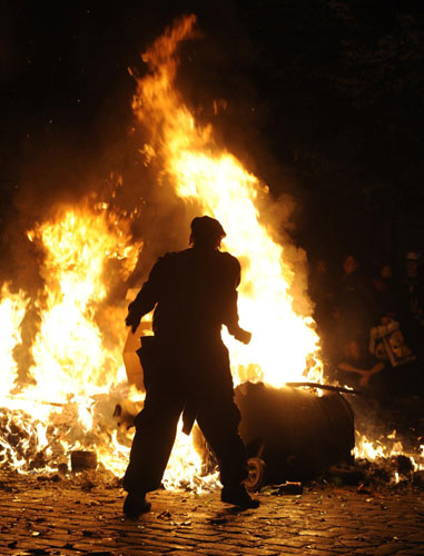A demonstrator stands in front of a burning street barricade during clashes at the so-called street party 'Schanzenfest' in the Schanze district in Hamburg August 20, 2011. Demonstrators clash with police in Hamburg