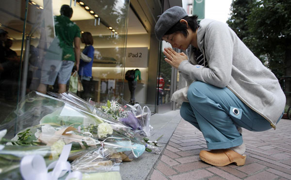Satoko Sakai prays in front of flowers offered in memory of Apple co-founder Steve Jobs, placed at the entrance of the Shibuya Apple store in Tokyo October 6, 2011. The world mourns Steve Jobs