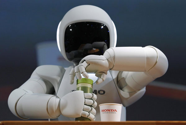Honda Motor Co's Asimo humanoid robot opens the top of a bottle to pour the drink into a cup during a news conference at the 42nd Tokyo Motor Show in Tokyo November 30, 2011. Tokyo Motor Show kicks off