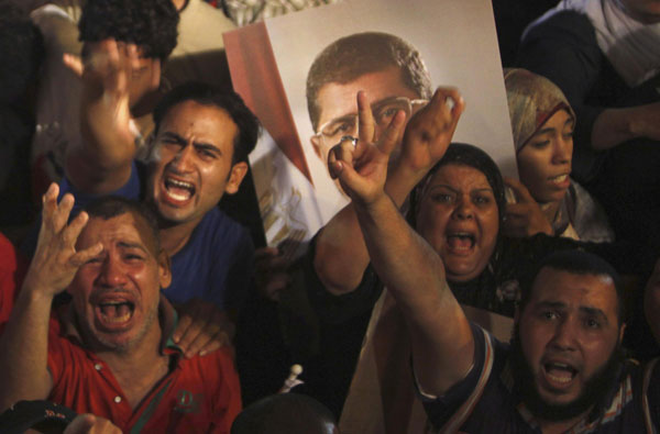 Supporters of Egypt's President Mohamed Mursi react after the Egyptian army's statement was read out on state TV, at the Raba El-Adwyia mosque square in Cairo July 3, 2013. Jubilant crowds celebrate after Morsi overthrown