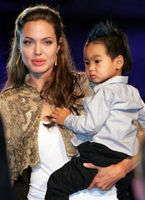 Actress Angelina Jolie, cradling her son Maddox, arrives at St. Mark's Square for the screening of her movie 'Shark Tale' at the 61st edition of the Venice Film Festival in Venice, northern Italy, in this file photo from Sept. 10, 2004. A paparazzo was arrested Thursday, June 22, 2006 after he was discovered hiding in bushes outside a daycare center attended by Jolie's adopted son, authorities said. Photographer Clint Brewer, 25, was trying to take pictures of 4-year-old Maddox Jolie-Pitt, according to Cindy Guagenti, a publicist for Jolie's partner, Brad Pitt.