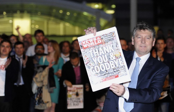 Colin Myler, editor of the News of The World, holds up a copy of the last edition of the newspaper outside the newspaper's office in Wapping, east London July 9, 2011. UK's News of the World bids farewell to readers