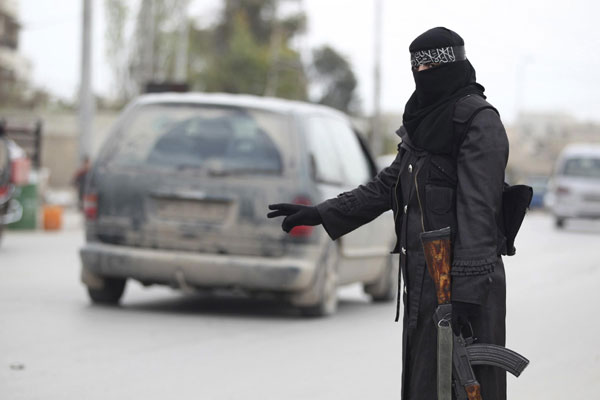 A woman member of the Al-Ikhlas (Loyalty) Battalion, stops a van at a checkpoint in Aleppo, March 31, 2013. Multiple blasts rock Syria