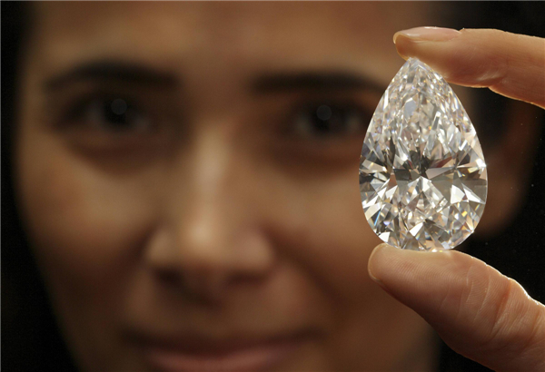 A Christie's member of staff displays a pear-shaped, D color, flawless diamond of 101.73 carats during an auction preview in Geneva, April 30, 2013. 101.73-carat diamond to be auctioned for over $20 million